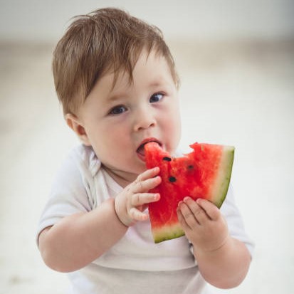 Niño de unos 8 meses comiendo un trozo de sandía / Credit: istockphoto user sanjeri ID:889504140