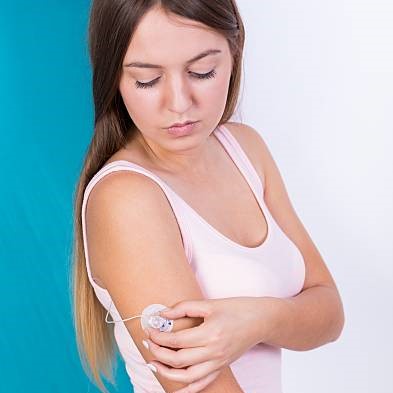 imagen chica mirándose y tocando el sensor de glucemia de su brazo / Credit: istockphoto user KatarzynaBialasiewicz ID:585601326