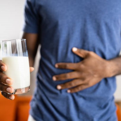 Hombre con un vaso de leche y tocándose la barriga de dolor / Credit: istockphoto user Andrei Popov ID:1354481568