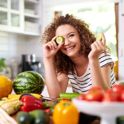 Mujer rodeada de frutas y verduras / Credit: istockphoto user gpointstudio ID:1173527649